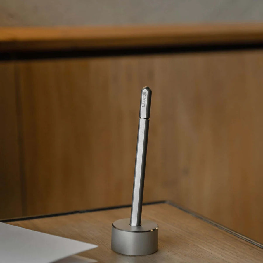 Stilform Titanium Base holding a Stilform pen, demonstrating its functional design